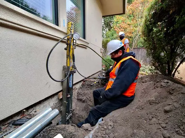 Professional foundation repair stabilization pier installation underpinning slab jacking crack injection waterproofing drainage solutions prevent settling structural safety contractor work warranty