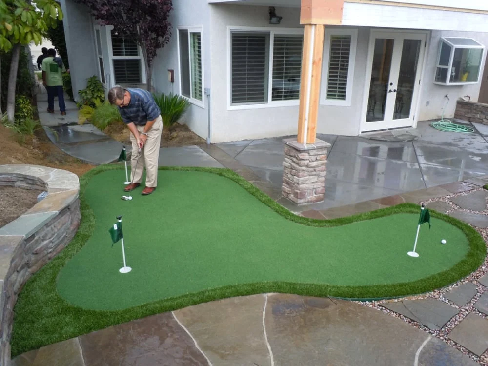 backyard putting green cost guide synthetic turf putting green pricing installation 2026 diy turf kit professional synthetic tour quality green chipping area full practice area modular system base prep drainage crushed aggregate compaction infill silica sand cup installation fringe area sand bunker golf practice backyard layout