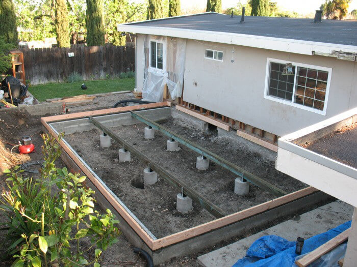 sunroom foundation concrete slab monolithic slab stem wall crawl space pier and beam helical piers footings below frost line rebar vapor barrier gravel base drainage french drain insulation